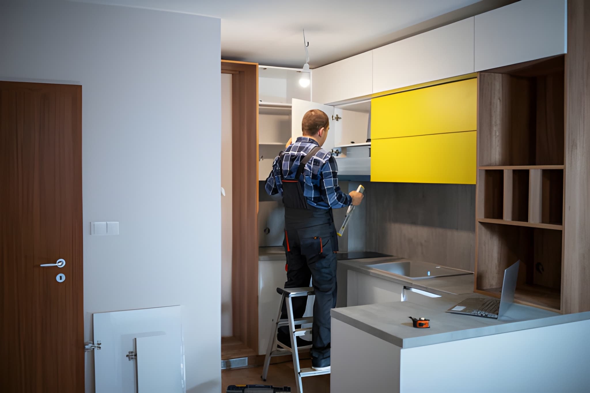 Kitchen remodeling West Palm Beach FL contractor measuring cabinets during modern renovation project