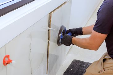 Installer using suction tool to place wall tile—Tile and Marble of Palm Beach