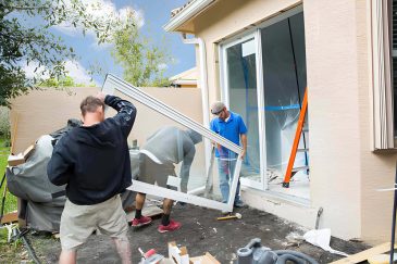 Hurricane impact window systems Palm Beach Gardens FL—team installs large sliding glass door at residence.